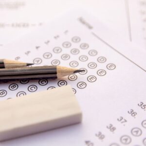 Child studying with open books and papers at a desk, concentrating — a visual representing how improving study habits can help improve performance on standardized tests.